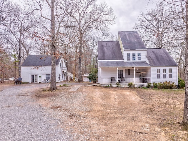 exterior space featuring a porch and dirt driveway