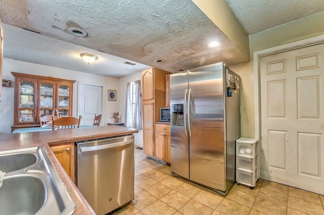 kitchen with visible vents, appliances with stainless steel finishes, a textured ceiling, and a sink