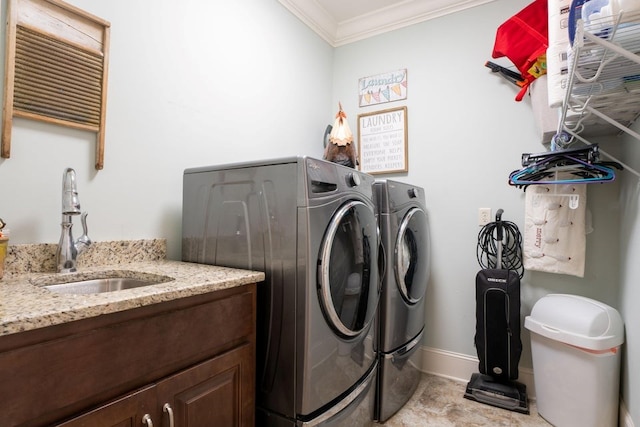 laundry room featuring crown molding, baseboards, laundry area, a sink, and washing machine and dryer