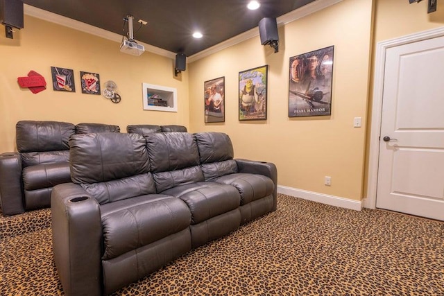 cinema room with ornamental molding and carpet