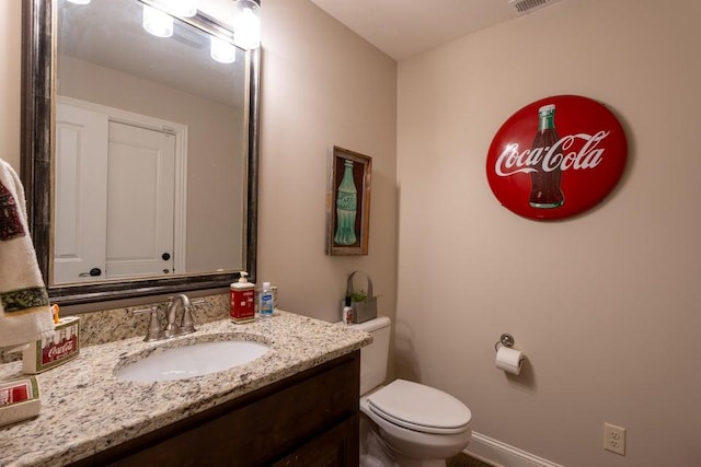bathroom with visible vents, toilet, and vanity