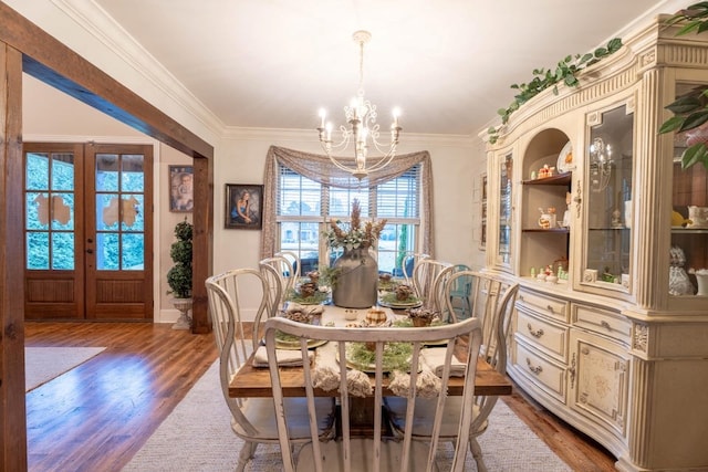 dining space featuring crown molding, wood finished floors, and a chandelier