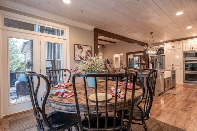 dining room featuring crown molding, sink, wood ceiling, and light wood-type flooring