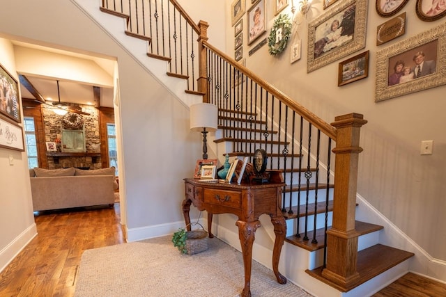 stairs featuring wood-type flooring and a high ceiling