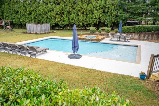 view of pool featuring an in ground hot tub, a patio area, and a lawn