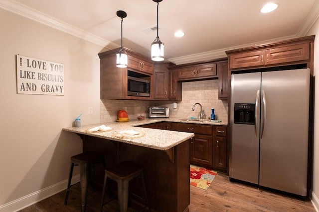 kitchen with tasteful backsplash, crown molding, a sink, a peninsula, and appliances with stainless steel finishes