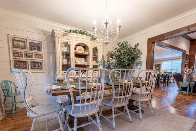 dining space featuring crown molding, hardwood / wood-style flooring, and a chandelier