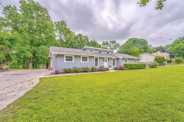 view of front of property featuring driveway and a front lawn