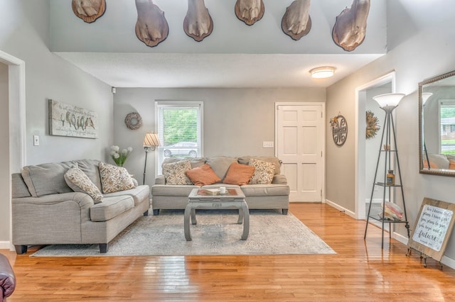 living area featuring baseboards and light wood-style flooring