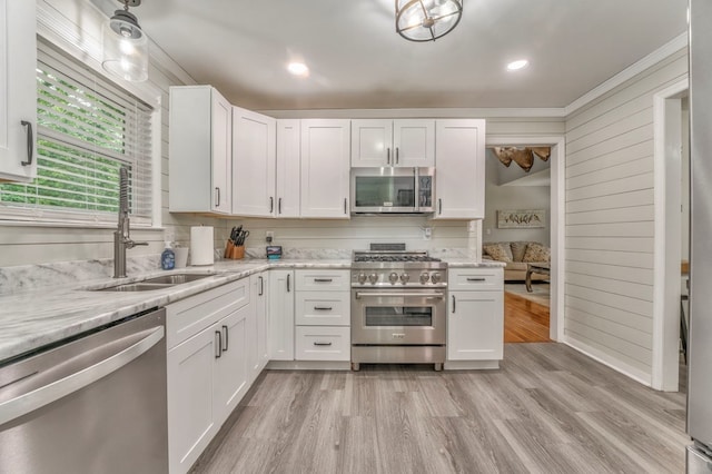 kitchen featuring light wood-type flooring, a sink, appliances with stainless steel finishes, and white cabinets
