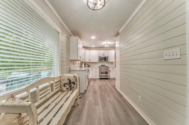 hallway featuring wooden walls and crown molding