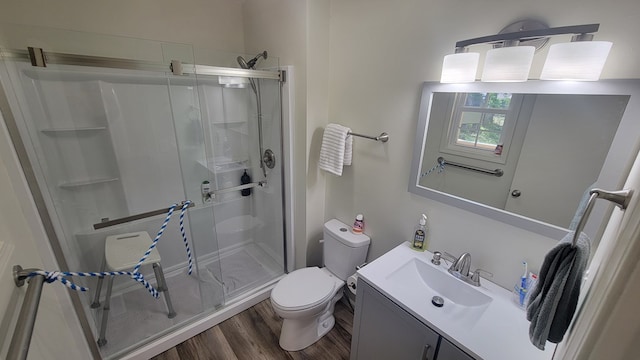 bathroom featuring vanity, wood-type flooring, an enclosed shower, and toilet