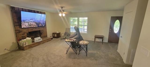 carpeted living room featuring ceiling fan and a fireplace