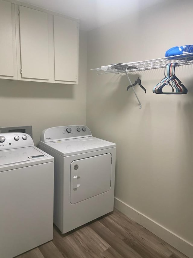 clothes washing area featuring independent washer and dryer, cabinets, and dark hardwood / wood-style flooring