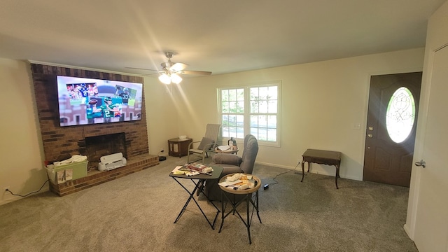 living room with a brick fireplace, ceiling fan, and carpet flooring