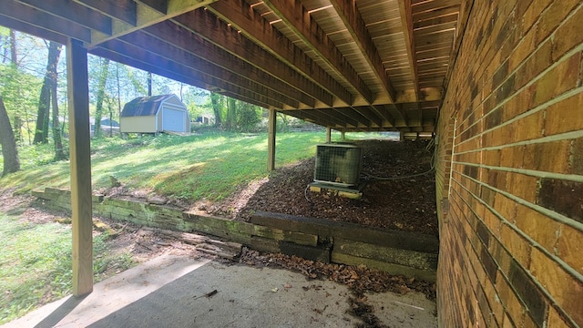 view of yard with central air condition unit and a shed