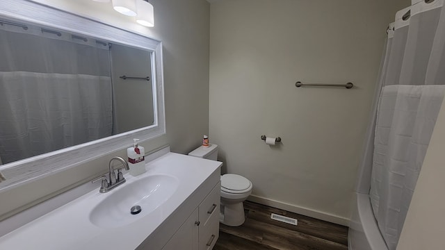 bathroom with hardwood / wood-style flooring, vanity, a shower with shower curtain, and toilet