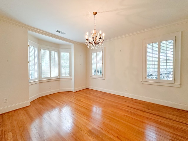 unfurnished room with crown molding, a notable chandelier, plenty of natural light, and hardwood / wood-style flooring