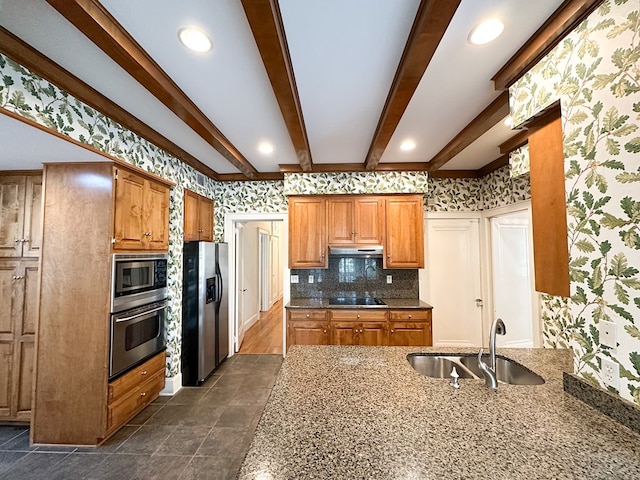 kitchen featuring stone countertops, beamed ceiling, sink, decorative backsplash, and stainless steel appliances