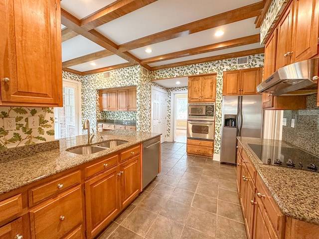 kitchen featuring sink, appliances with stainless steel finishes, backsplash, beam ceiling, and light stone counters