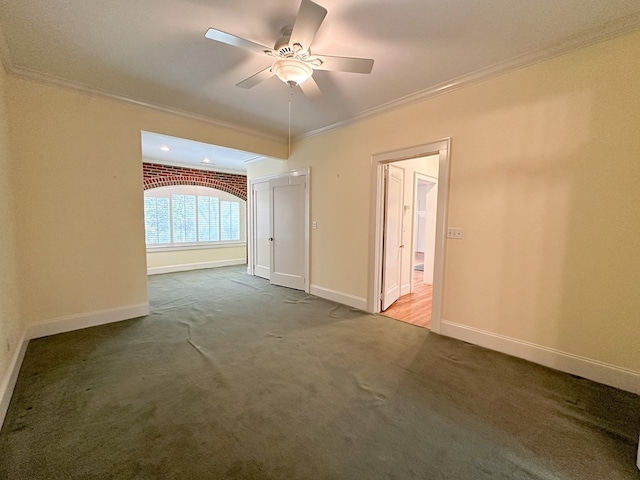 carpeted empty room featuring ornamental molding and ceiling fan