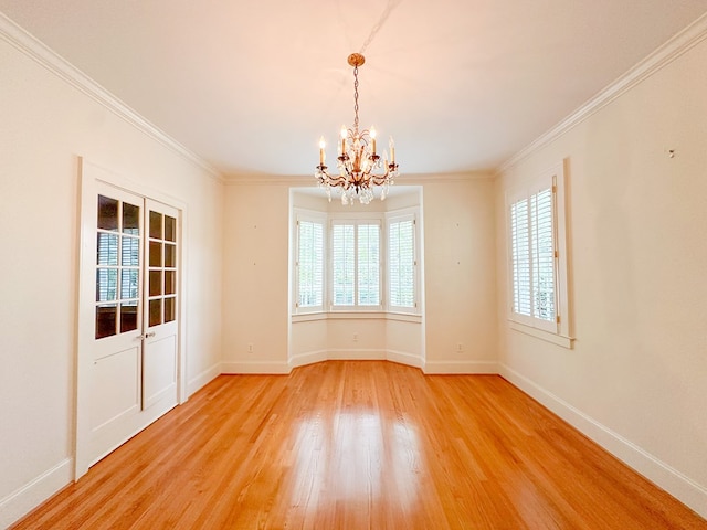 unfurnished dining area featuring hardwood / wood-style floors, crown molding, and a chandelier