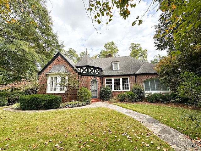 english style home featuring a front yard