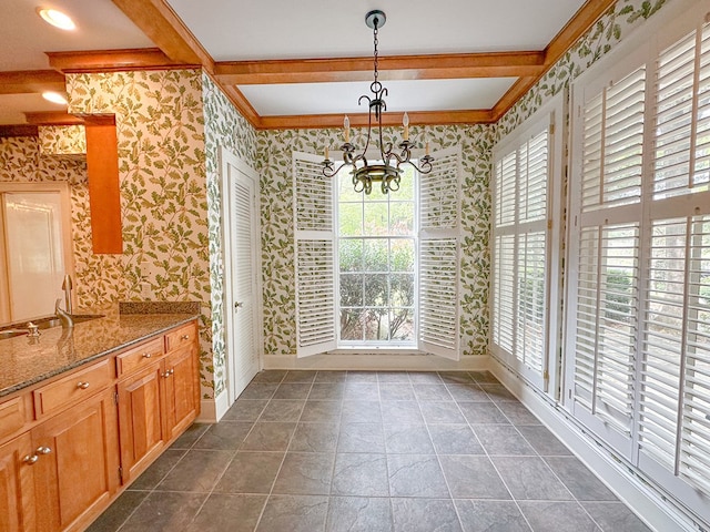 unfurnished dining area with ornamental molding, beam ceiling, and a chandelier