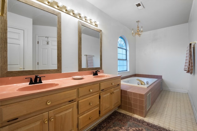 bathroom with a garden tub, double vanity, a sink, and visible vents