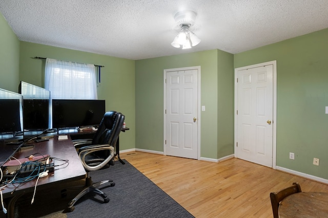 office space featuring a textured ceiling, baseboards, and wood finished floors