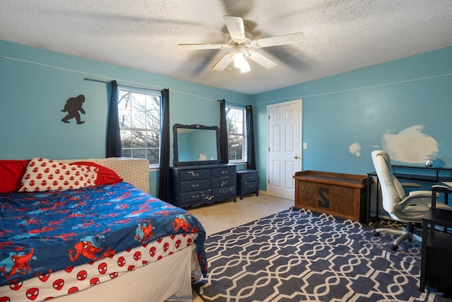 carpeted bedroom with a textured ceiling and ceiling fan