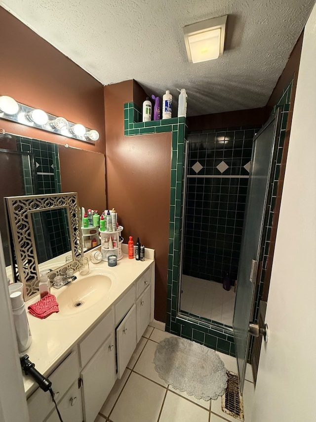 bathroom featuring vanity, tile patterned floors, a textured ceiling, and walk in shower