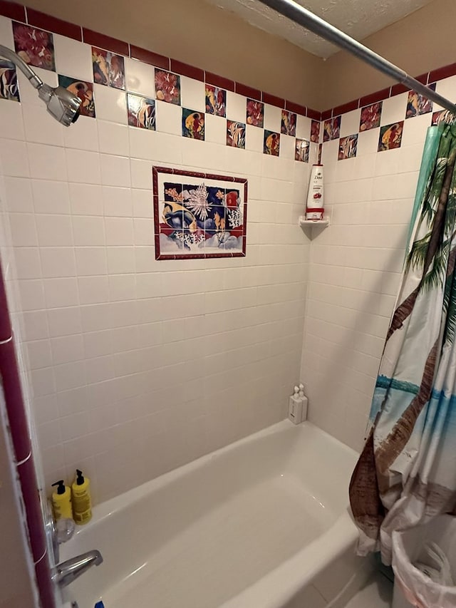 bathroom with a textured ceiling and shower / bath combo