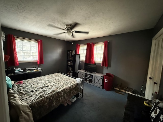 bedroom with a closet, ceiling fan, carpet floors, and a textured ceiling