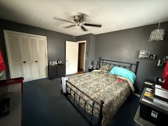 bedroom with a textured ceiling, a closet, ceiling fan, and dark colored carpet