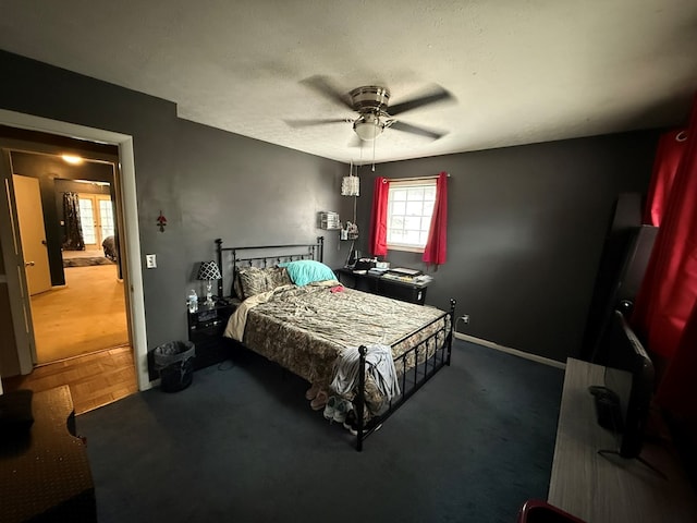 bedroom featuring ceiling fan, parquet flooring, and a textured ceiling