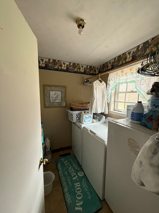 washroom featuring tile patterned floors, washing machine and dryer, and a textured ceiling