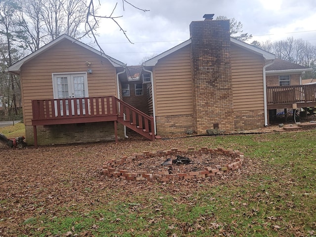 view of side of home featuring a wooden deck and a fire pit