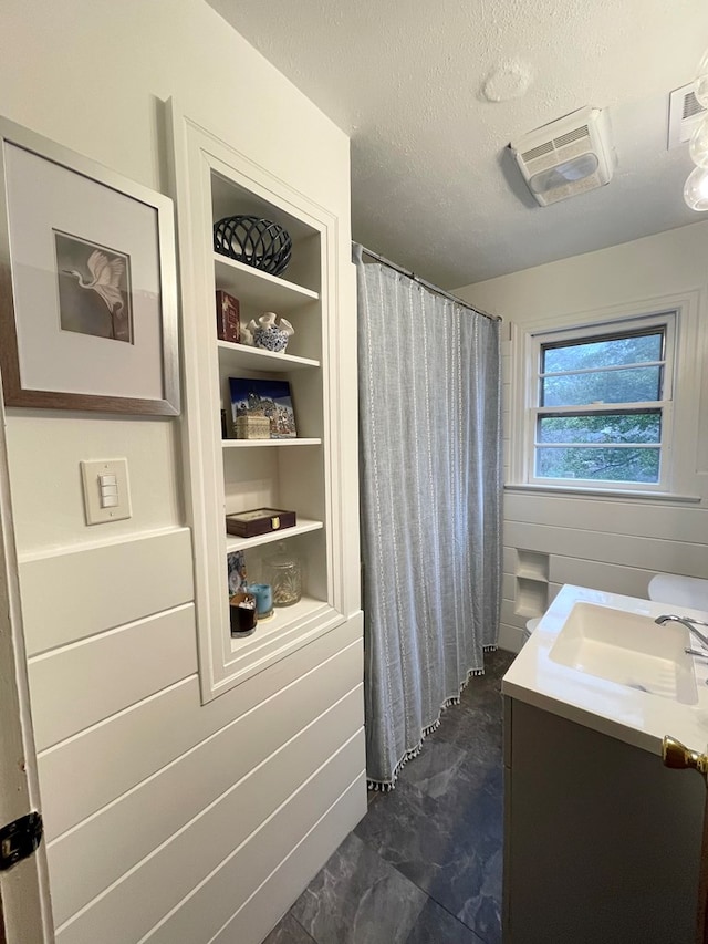 bathroom featuring vanity, built in features, a textured ceiling, and a shower with shower curtain