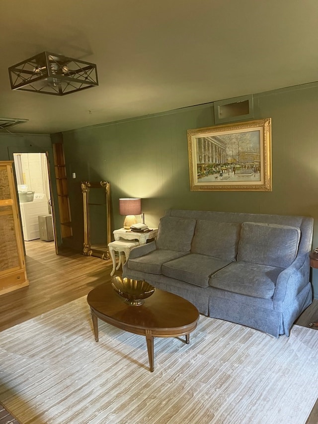 living room with washer / dryer and light hardwood / wood-style floors