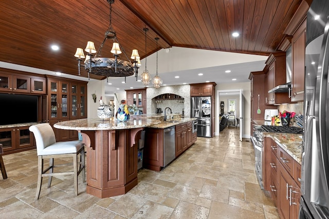 kitchen featuring appliances with stainless steel finishes, hanging light fixtures, a large island, wood ceiling, and light stone countertops