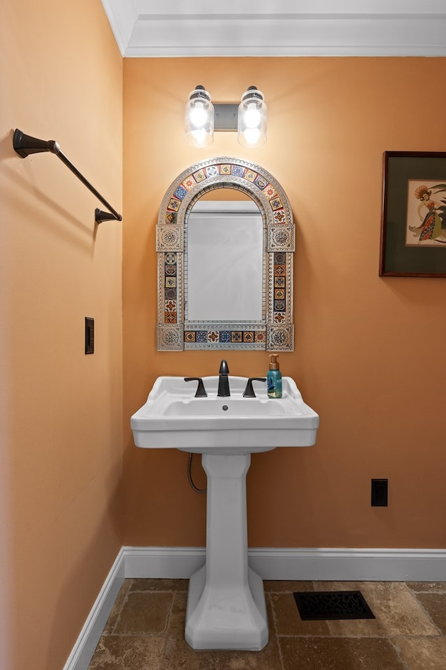 bathroom featuring crown molding and sink