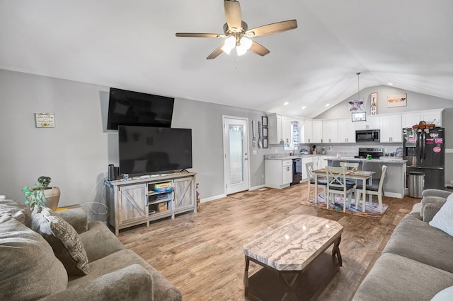 living room with vaulted ceiling, ceiling fan, and light hardwood / wood-style floors