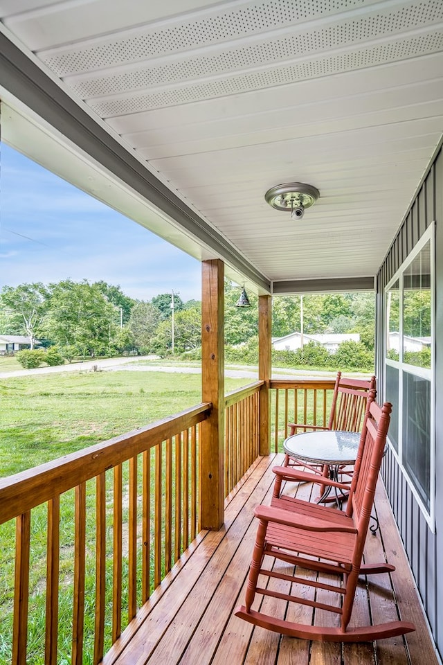 wooden deck featuring a yard and covered porch