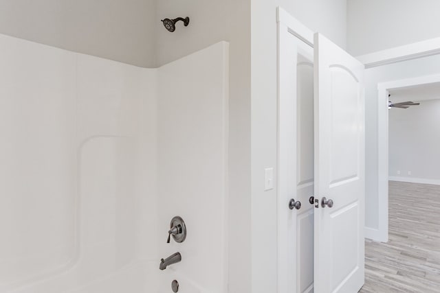 bathroom with hardwood / wood-style flooring and  shower combination