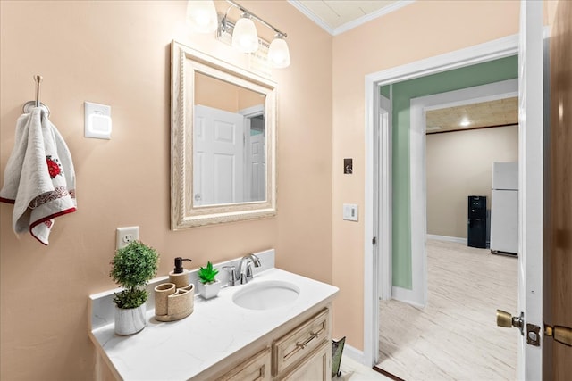 bathroom with vanity, crown molding, and baseboards