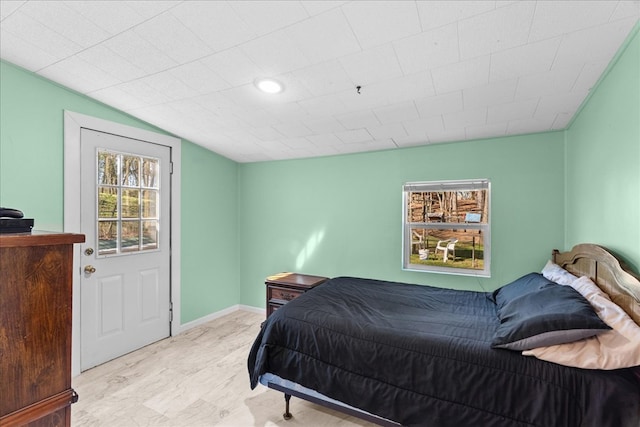 bedroom featuring lofted ceiling and baseboards