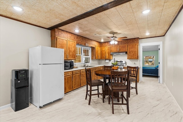 kitchen with black microwave, under cabinet range hood, range, freestanding refrigerator, and a sink