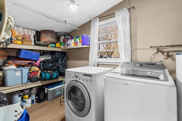 clothes washing area with laundry area, washer and dryer, and wood finished floors