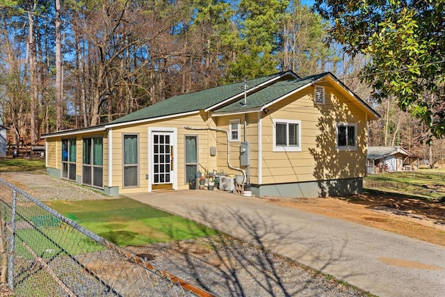 exterior space with roof with shingles and fence